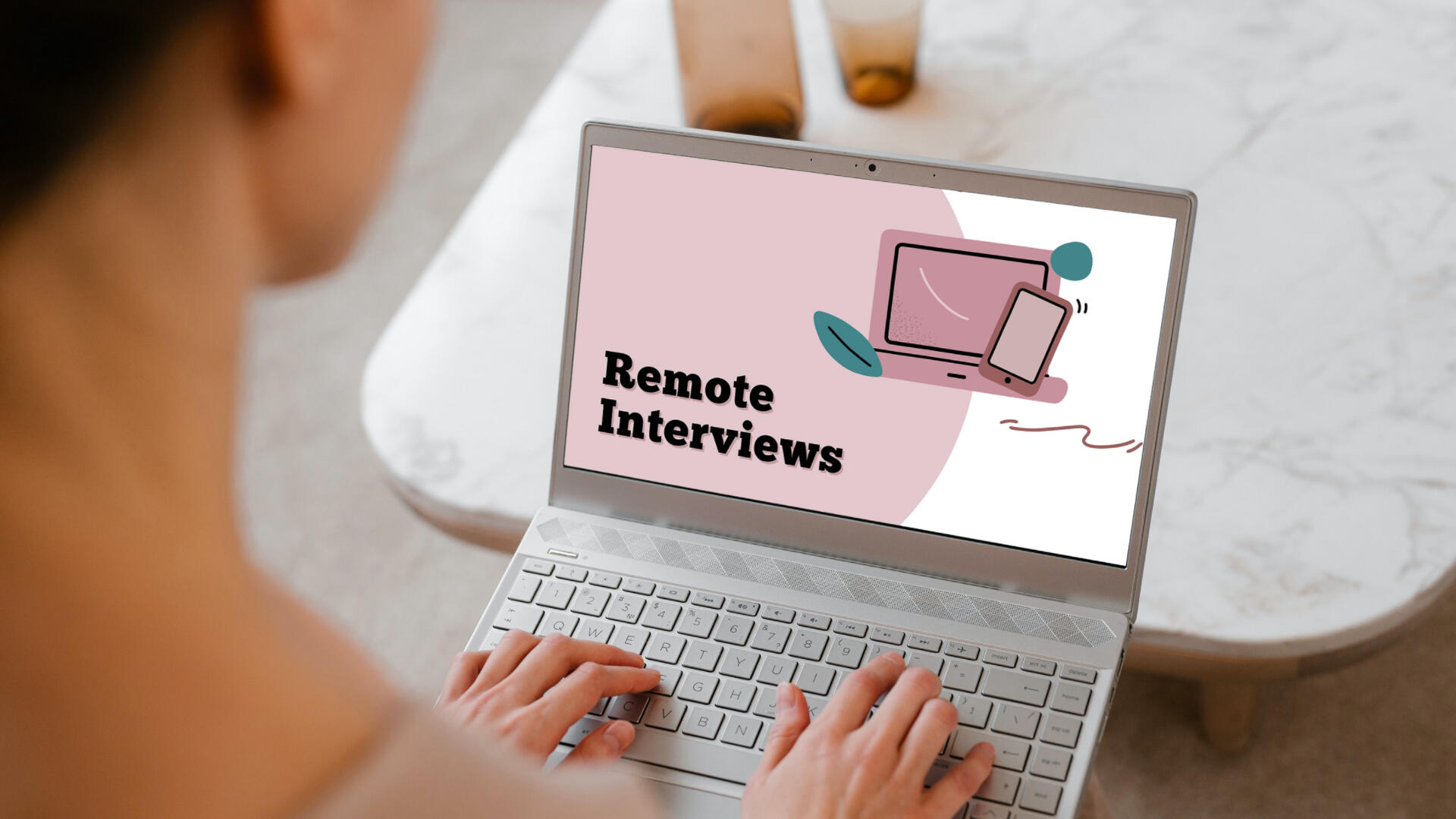 Woman at a laptop with a screen showing "Remote Interviews" title page.