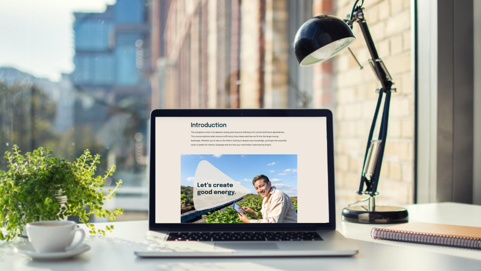 Computer facing a city-view showing the cover page of this course.